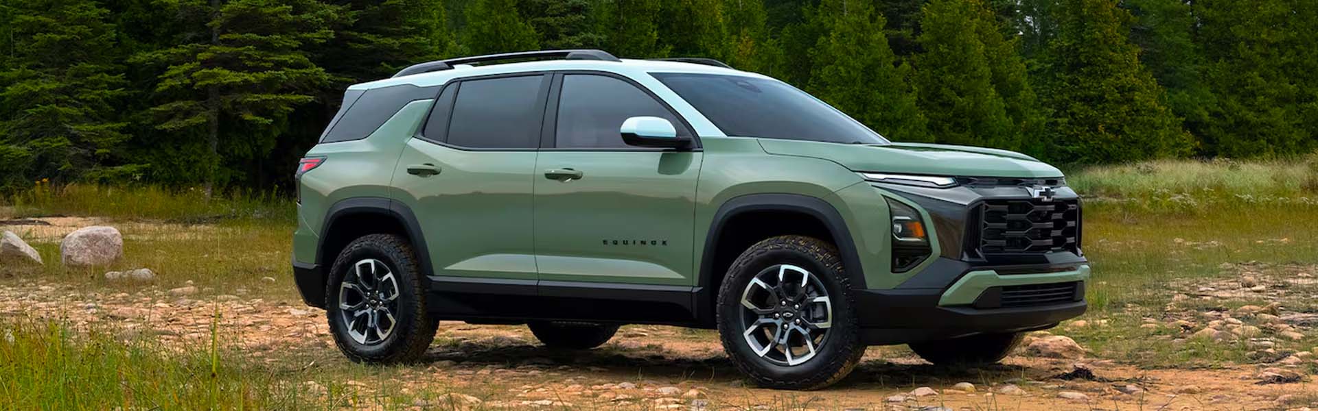 Green Chevrolet Equinox SUV on a wooded trail.